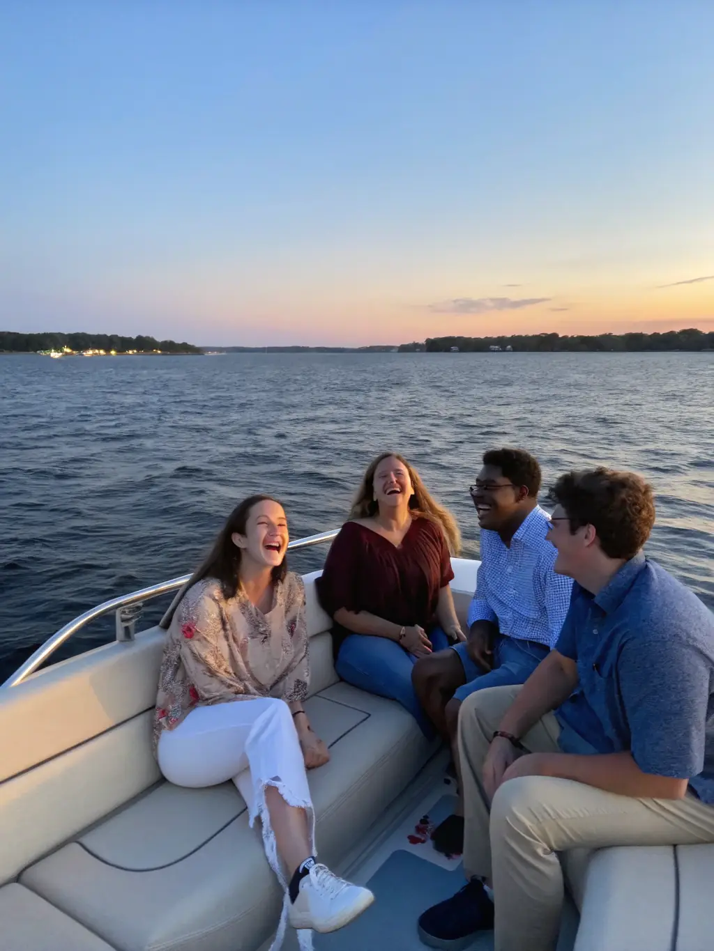 A picturesque image of a group of friends enjoying a custom charter, with a boat cruising towards a waterfront restaurant at sunset, highlighting the personalized and flexible nature of Two For Hooking's private charters.